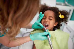Dentist checking small girl's teeth