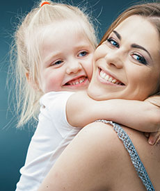 woman holding her baby girl and smiling
